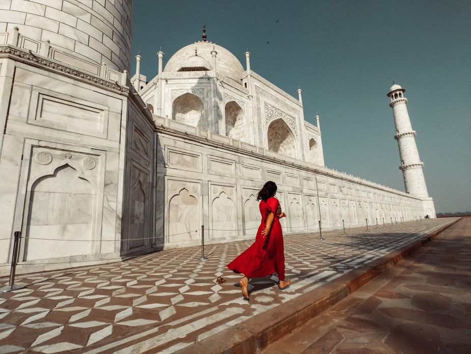 a-woman-in-red-passes-the-taj-mahal.jpg