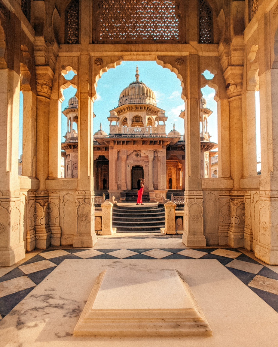 stone-archway-looks-out-to-a-tall-building-with-circular-roof.jpg